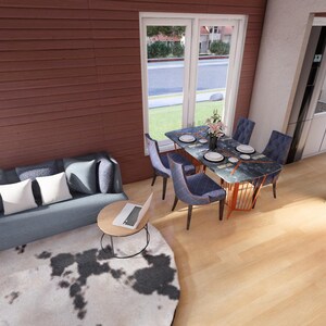 May include: Interior shot of a living room with a blue sofa, pillows, and a round coffee table with a laptop. A dining table with chairs is set near a window. The room has hardwood floors and a cowhide rug.