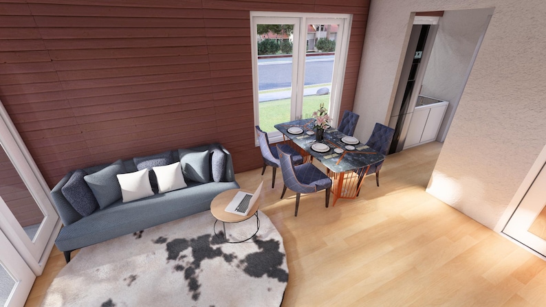 May include: Interior shot of a living room with a blue sofa, pillows, and a round coffee table with a laptop. A dining table with chairs is set near a window. The room has hardwood floors and a cowhide rug.