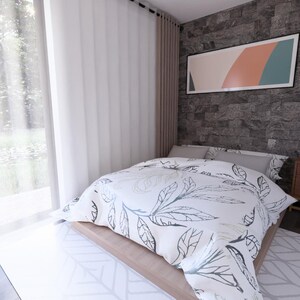 May include: A modern bedroom with a bed covered in a white and gray leaf-patterned comforter. The room features a gray stone accent wall, a wooden nightstand, and a large window with sheer curtains. An abstract artwork hangs above the bed.