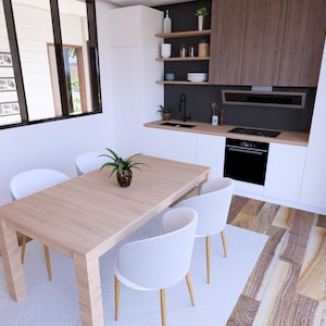 Puede incluir: Una cocina y comedor modernos con una mesa de comedor de madera clara y cuatro sillas blancas. La cocina cuenta con gabinetes blancos, un horno negro y gabinetes superiores de madera. Una peque&ntilde;a planta est&aacute; sobre la mesa.