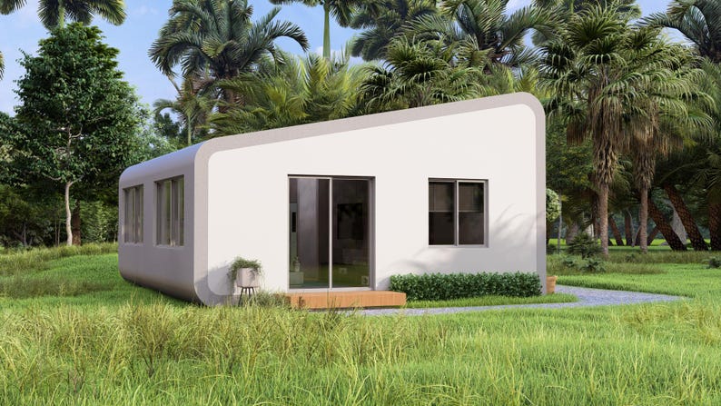 May include: A contemporary white prefabricated house with a sloping roof and curved edges. The building has large windows, a sliding glass door, and a small wooden deck. It is set in a tropical environment with green grass and palm trees.