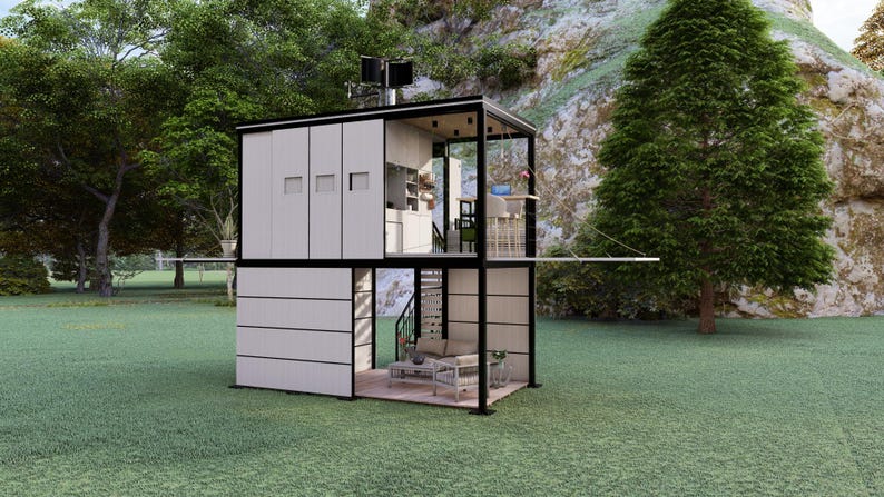 Op de afbeelding: Een modern, tweeledig tiny house met een zwart frame en witte gevelbekleding. De structuur heeft grote ramen, een klein balkon en een minimalistisch interieur. Het huis staat op een grasveld met bomen en een rotsachtige heuvel op de achtergrond.