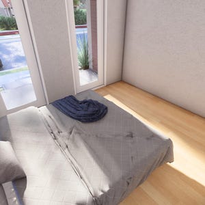 May include: Bedroom interior with a bed, pillows, and a blanket. A black lamp sits on a black nightstand next to the bed. Large windows and a door provide natural light. The room has light-colored walls and hardwood floors.