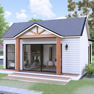 Puede incluir: Una casa peque&ntilde;a y moderna con exterior blanco, tejado gris oscuro y porche de madera. La casa tiene grandes puertas correderas y ventanas de cristal, rodeada de c&eacute;sped verde y &aacute;rboles. Un coche blanco est&aacute; aparcado en la calle.