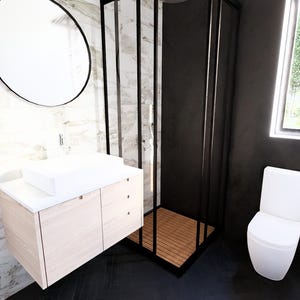 K&ouml;nnte beinhalten: Modernes Badezimmer-Design mit einem wei&szlig;en, rechteckigen Waschbecken auf einem hellen Holzwaschtisch. Ein gro&szlig;er, runder Spiegel mit schwarzem Rahmen h&auml;ngt dar&uuml;ber. Eine schwarz gerahmte Duschkabine und eine wei&szlig;e Toilette vervollst&auml;ndigen den Raum.