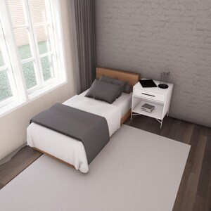 Peut inclure: Chambre minimaliste avec un lit simple, une couverture et un oreiller gris. Une table de chevet blanche avec un ordinateur portable et des &eacute;l&eacute;ments de d&eacute;coration est &agrave; c&ocirc;t&eacute; du lit. Une grande fen&ecirc;tre avec des stores blancs et un rideau gris sont visibles.