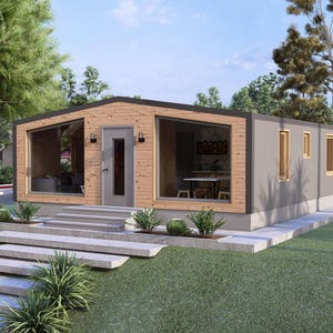 May include: A contemporary prefabricated house with a grey exterior and wooden features. Large windows reveal the interior, including a dining table. The house has a small front porch with steps and is surrounded by greenery.
