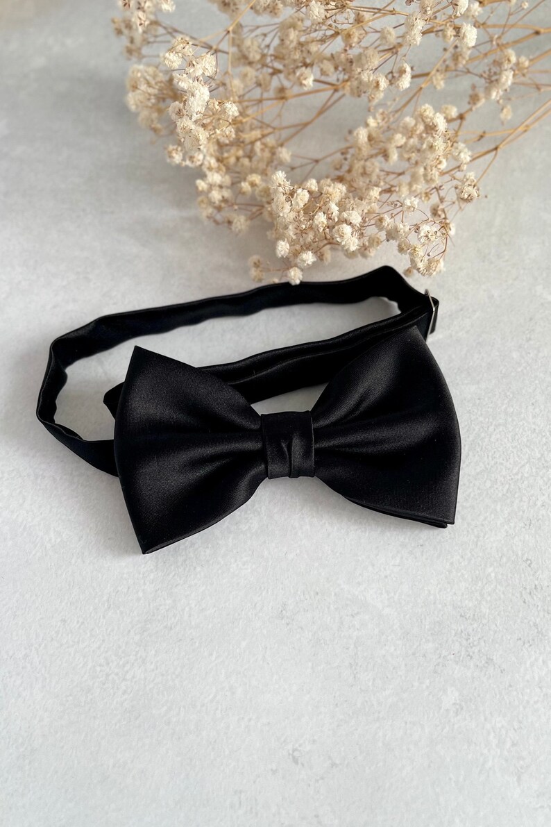 May include: A black satin bow tie with an adjustable strap.