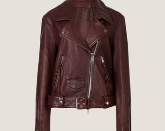 Könnte beinhalten: Eine burgunderfarbene Lederjacke im Biker-Stil mit Reißverschluss, Gürtel in der Taille und Reißverschlusstaschen.