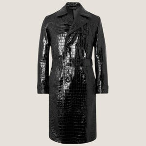 Peut inclure: Un long trench-coat noir brillant avec une texture effet crocodile. Le manteau présente une coupe croisée, une ceinture à la taille et un col classique. Un vêtement d'extérieur élégant.