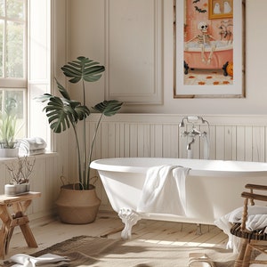 K&ouml;nnte beinhalten: Ein Badezimmer mit einer wei&szlig;en Badewanne mit L&ouml;wenf&uuml;&szlig;en, einem gerahmten Kunstwerk und einer gro&szlig;en Topfpflanze. Das Kunstwerk zeigt ein Skelett in einer Badewanne. Ein gewebter Teppich und ein Holzschemel erg&auml;nzen die Einrichtung. Der Raum hat eine neutrale Farbpalette.