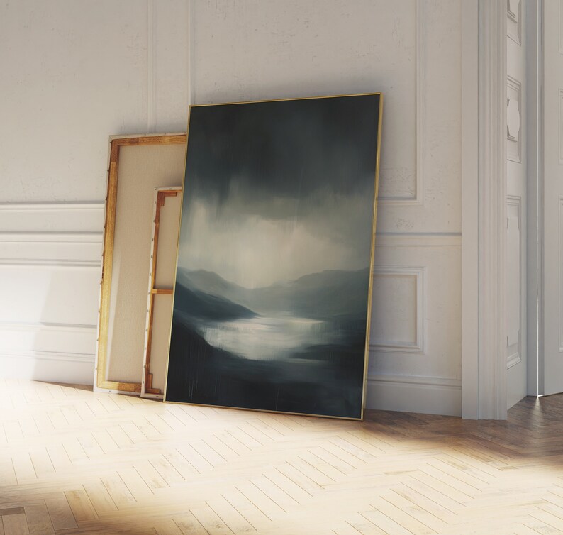 May include: A framed abstract landscape painting with a blue and gray color scheme. The painting depicts a misty scene with a lake and mountains in the distance.