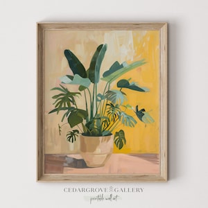 May include: A painting of a potted plant with large green leaves against a yellow background. The plant is in a light brown pot and is sitting on a light pink surface. The painting is framed in a light wood frame.