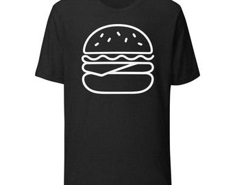 May include: Black t-shirt featuring a white outline of a hamburger. The burger design includes a bun, patty, cheese, and other toppings. The shirt is made of a soft material.