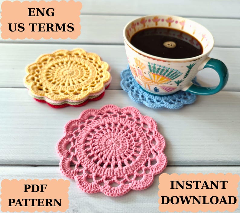 May include: A cup of coffee sits on a blue crocheted coaster, with additional crocheted coasters in yellow and pink nearby. The coasters are circular with a scalloped edge. Text in the image reads "ENG US TERMS", "PDF PATTERN", and "INSTANT DOWNLOAD".