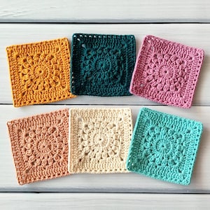 May include: Six colourful, square crochet coasters in shades of yellow, teal, pink, peach, cream, and teal. Each coaster features a detailed floral pattern in the centre, with a textured border.