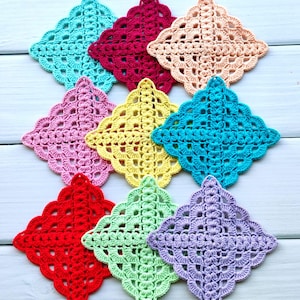 May include: Nine colorful, handmade crochet coasters in shades of teal, burgundy, peach, pink, yellow, turquoise, red, green, and lavender. Each coaster features a diamond-shaped design with a scalloped edge, perfect for adding a touch of handmade charm to any space.