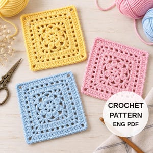 Puede incluir: Tres motivos cuadrados de ganchillo en amarillo, rosa y azul claro, cada uno con un diseño floral central. Hay unas tijeras de metal y ovillos de lana. Una etiqueta blanca circular muestra el texto CROCHET PATTERN ENG PDF.