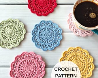 May include: A collection of six round, scalloped-edge crochet coasters in red, light green, light blue, pink, and yellow, with one coaster supporting a ceramic mug filled with dark coffee. A white circular overlay displays the text CROCHET PATTERN ENG PDF.