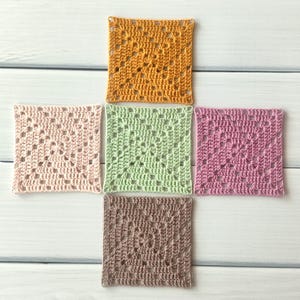 May include: Five square crochet motifs arranged in a cross pattern. The top square is mustard yellow, the left is pale pink, the centre is light green, the right is mauve, and the bottom is taupe. Each piece features a classic openwork granny square design.