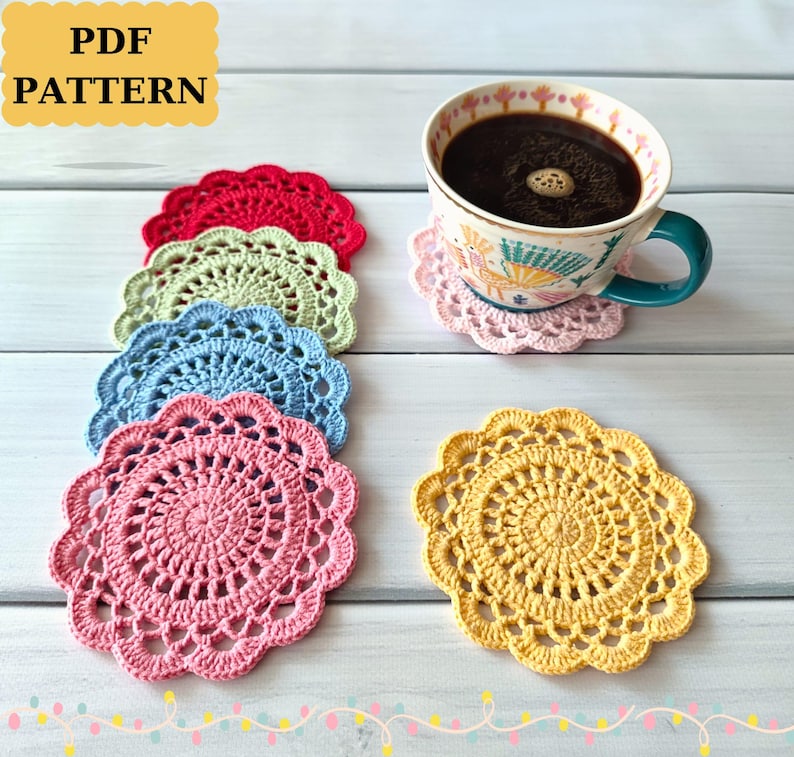 May include: A collection of colorful, crocheted coasters in red, green, blue, pink, and yellow. A cup of coffee sits on a pink coaster. The image includes the text "PDF PATTERN".