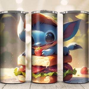 May include: A stainless steel tumbler featuring a cartoon creature with large eyes, perched atop a sandwich with lettuce, tomato, and a strawberry. The design is rendered in soft, pastel colors, creating a whimsical and appealing aesthetic.