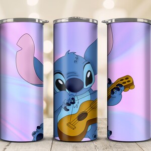 May include: A stainless steel tumbler featuring a cartoon illustration of Stitch playing a ukulele. The design is set against a pastel purple and pink gradient background. The tumbler has a silver lid and is designed to hold beverages.
