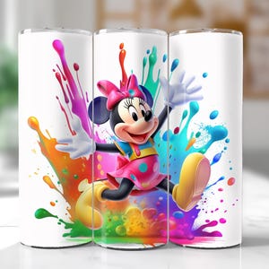 Puede incluir: Vaso blanco con Minnie Mouse con vestido y lazo rosa, rodeada de salpicaduras de pintura coloridas. El dise&ntilde;o incluye acentos amarillos, azules, verdes, naranjas y morados, creando un aspecto vibrante.