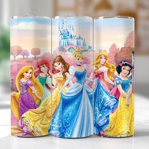 Könnte beinhalten: Drei Edelstahlbecher mit einem farbenfrohen Design von Disney-Prinzessinnen. Das Design umfasst Rapunzel, Arielle, Belle, Aschenputtel, Aurora und Schneewittchen, mit einem Schloss und einem rosa Landschaftshintergrund.