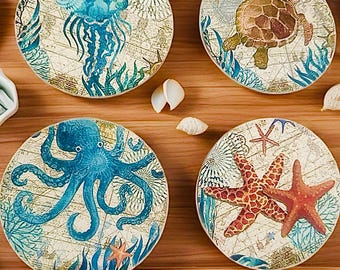 May include: Set of four round coasters featuring a nautical theme. Each coaster has a different sea creature, including a jellyfish, a turtle, an octopus, and a starfish. The coasters are beige with blue, green, and red accents.