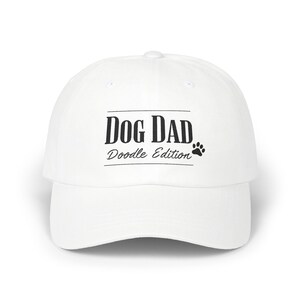 May include: White baseball cap with black text that reads "Dog Dad Doodle Edition" and a paw print.