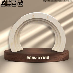 May include: A wooden archway design with three concentric layers, displayed on a dark brown, circular base. The base has the text "BANU AYDIN" in white. The image also includes file type icons for DXF, DWG, PDF, and SVG.