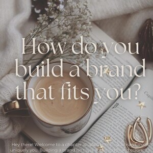 May include: A cup of coffee sits on an open book with a quote about building a brand that fits you. The book is surrounded by white flowers and a gold earring.