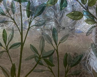 May include: A close-up of a window film with a botanical design. The film features green leaves and stems against a textured, iridescent background. The leaves vary in shades of green.