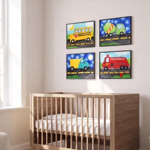 May include: Four rectangular wall art prints featuring colorful vehicles including a yellow school bus, a green cement mixer, a blue dump truck, and a red fire truck, all displayed on a light wall above a wooden crib with white bedding.