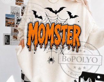 May include: A cream-colored crewneck sweatshirt featuring a graphic print with the orange text MOMSTER in a dripping font style. The design includes black silhouettes of three flying bats, a spider web, and a hanging spider centered below the text.