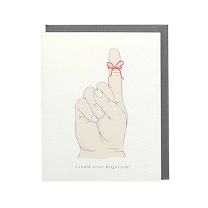 May include: A white card with a hand drawn illustration of a hand with a red string tied around the index finger. The text "i could never forget you!" is printed below the hand.