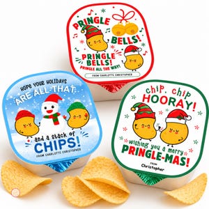 May include: Three snack containers with custom holiday-themed lids. One lid features Pringle Bells text with cartoon chips in hats. Another shows a snowman and chips with text about holidays. The third says chip, chip hooray with festive chips.
