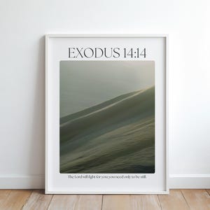 May include: A framed print featuring the text "EXODUS 14:14" at the top and a quote at the bottom. The image within the frame depicts a landscape of undulating hills in tones of green and grey. The frame is white.