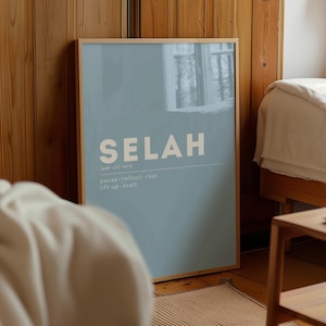 Könnte beinhalten: Ein gerahmtes Poster mit dem Wort "SELAH" in großen, weißen Buchstaben auf hellblauem Hintergrund. Darunter die Definition mit "pause, reflect, rest, lift up, exalt". Der Rahmen ist hellbraun, und das Poster lehnt an einer Holzwand.