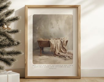 May include: A framed print featuring a wooden manger with a draped beige blanket. The background is a soft, neutral color palette. The text at the bottom reads: "BUT GOD DID NOT WITHHOLD HIS OWN SON BUT GAVE HIM UP FOR US ALL. Romans 8:32."