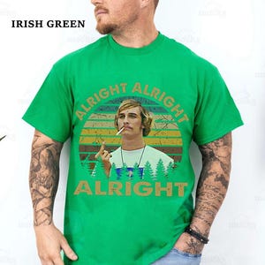 Puede incluir: Camiseta verde irland&eacute;s con un gr&aacute;fico de un hombre con un cigarrillo y las palabras "ALRIGHT ALRIGHT ALRIGHT" en un dise&ntilde;o retro. La camiseta es de color liso y tiene cuello redondo.