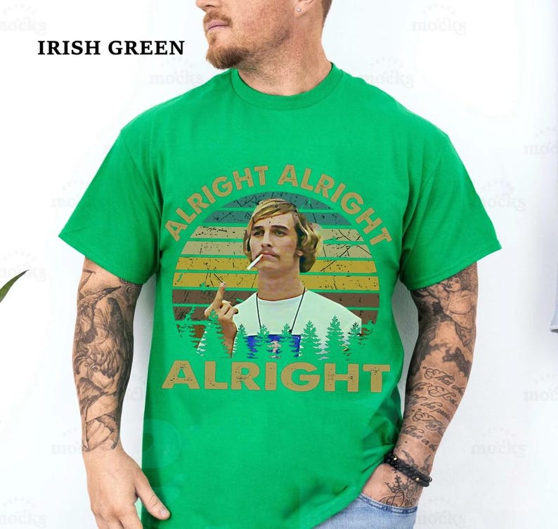 Puede incluir: Camiseta verde irland&eacute;s con un gr&aacute;fico de un hombre con un cigarrillo y las palabras "ALRIGHT ALRIGHT ALRIGHT" en un dise&ntilde;o retro. La camiseta es de color liso y tiene cuello redondo.