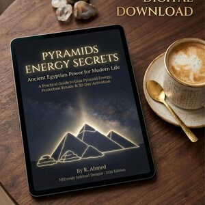 May include: A digital download displayed on a tablet, titled "PYRAMIDS ENERGY SECRETS." The cover features glowing pyramid illustrations. Text reads "Ancient Egyptian Power for Modern Life" and "40-PAGE DIGITAL DOWNLOAD." A cup of coffee and decorative stones are also present.