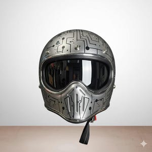 Peut inclure: Casque de moto argenté avec un motif de circuit imprimé. Le casque est équipé d'une visière sombre et d'une mentonnière. Fabriqué en métal, il est doté d'une sangle noire. Un casque alliant sécurité et design.