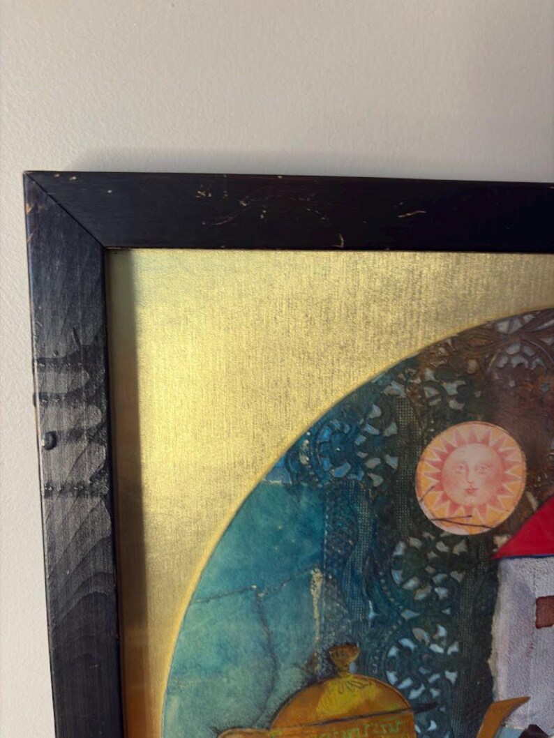 The top left corner of the black wooden frame showing signs of surface scratches and aged texture. This corner includes a visible portion of the red sun, teapot lid, and deep blue background pattern that resembles embroidered fabric.