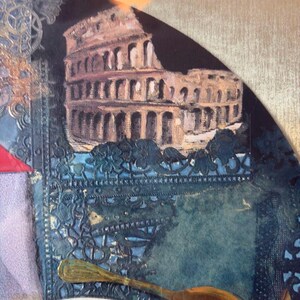 Zoomed-in portion highlighting the Roman Colosseum at the top right of the collage. A golden spoon floats below it, and the intricate blue lace pattern continues across the background. Subtle paint texture and cut paper shapes bring depth and complexity to this section.