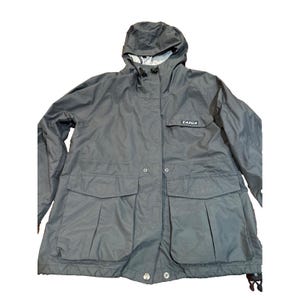 May include: A dark gray hooded jacket with the brand name "TAIGA" on the chest. The jacket has two large front pockets, a zipper closure, and a drawstring hood. The jacket is made of a lightweight, water-resistant material.