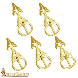 Puede incluir: Conjunto de cinco hebillas de cinturón de metal dorado con un diseño puntiagudo decorativo. Cada hebilla tiene una punta puntiaguda y un adorno decorativo.