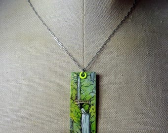 May include: A rectangular pendant necklace with a silver chain. The pendant features a hand-painted waterfall scene in shades of green, white, and black. The pendant is approximately 1.5 inches long and 0.75 inches wide. The pendant is attached to the chain with a neon green loop.